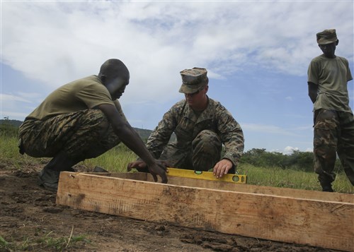 U.S. Marine Cpl. Brandon Ditmire, a combat engineer with Special-Purpose Marine Air-Ground Task Force Crisis Response-Africa, assists a Uganda People’s Defense Force soldier level the base for a concrete slab during a civil engineering exercise at Camp Singo, Nov. 16, 2015. The exercise helps the partner nations fortify their civil engineering skills while strengthening the bond between the two. (U.S. Marine Corps photo by Cpl. Olivia McDonald/Released)