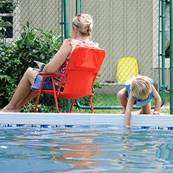 Mother and young child next to a swimming pool.