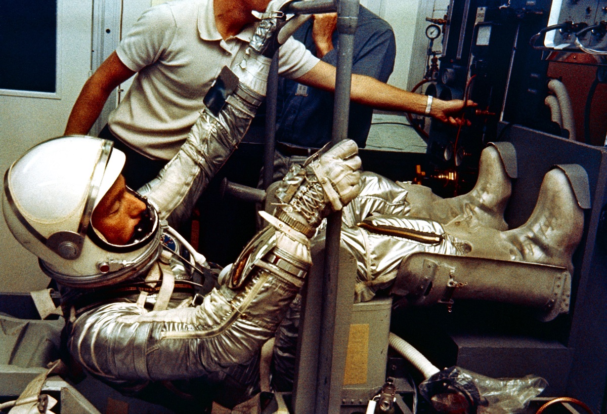 In the Hanger S crew quarters prior to the Mercury Atlas-7 flight in May of 1962, Scott Carpenter participates in a checkout of his pressure suit. Image Credit: NASA.

