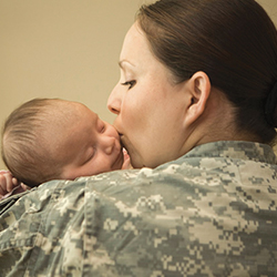 A service member holding her sleeping baby