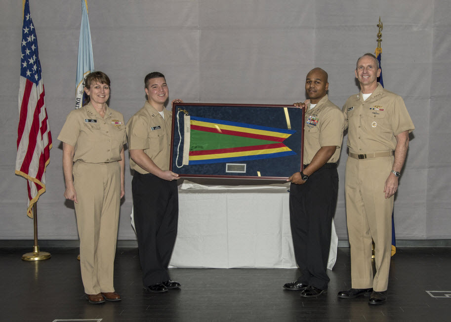 FORT MEADE, Md. (December 17, 2014) Chief of Naval Operations Adm. Jonathan Greenert, assisted by U.S. Fleet Cyber Command/ U.S. 10th Fleet Sailors of the Year Cryptologic Technician (Networks) 1st Carlos Shelmire and Yeoman 1st Class Demetrius Martinez, present Vice Adm. Jan E. Tighe, commander of U.S. Fleet Cyber Command/ U.S. 10th Fleet, with the Navy Unit Commendation Flag during a ceremony held at Fort Meade, Maryland. Department of Defense Photo.