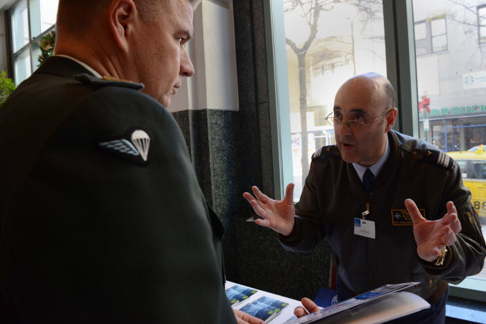 Colonel Fernando Duarte discusses the Joint Analysis and Lessons Learned Centre exhibit during the 2014 COTC. Photo by ACT PAO.