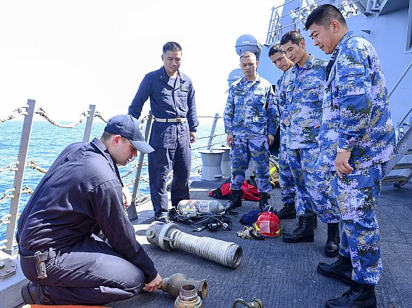 GULF OF ADEN (Dec. 11, 2014) Hull Maintenance Technician 1st Class Donipaul Briscoe, left, discusses various damage control tools with members of the Chinese People's Liberation Army (Navy) PLA(N) aboard the guided-missile destroyer USS Sterett (DDG 104) during U.S. - China Counter-Piracy Exercise 15. Sterett is deployed as part of the Carl Vinson Carrier Strike Group and is supporting Operation Inherent Resolve conducting maritime security operations, strike operations in Iraq and Syria as directed and theater security cooperation efforts in the U.S. 5th Fleet area of responsibility. U.S. Navy photo by Mass Communication Specialist 3rd Class Eric Coffer.