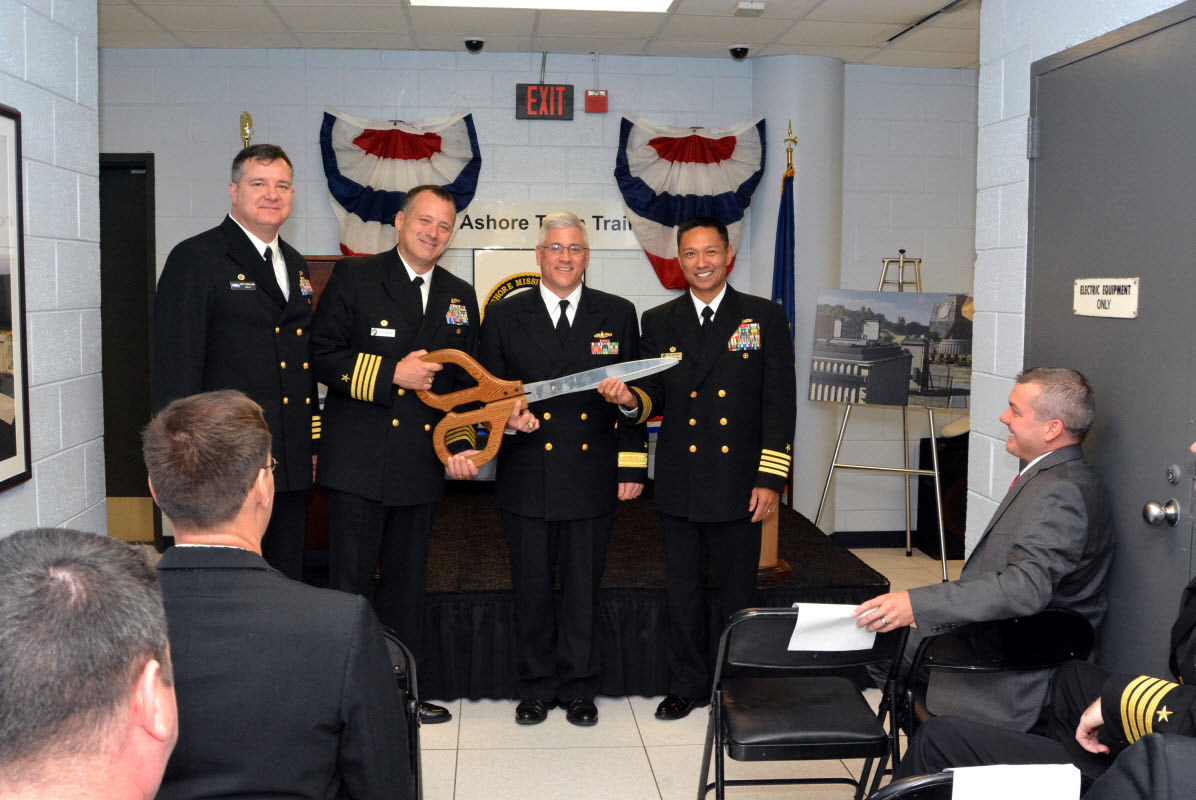 VIRGINIA BEACH, Va. (Nov. 7, 2014) From right, Capt. Leonard Remias, commanding officer of Center for Surface Combat Systems Unit Dam Neck, Rear Admiral Lawrence E. Creevy, deputy commander for surface warfare, Naval Sea Systems Command, Capt. Bill McKinley, commanding officer of Center for Surface Combat Systems and Capt. Jeffrey Sinclair, the program manager for Surface Training Systems Program Office, pose with scissors before cutting the ceremonial ribbon for the Aegis Ashore Team Trainer Facility at Gallery Hall aboard Dam Neck. U.S. Navy photo by Mass Communication Specialist 2nd Class Alysia R. Hernandez.