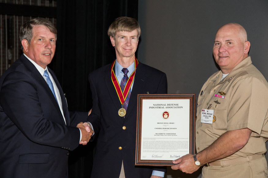 Naval Surface Warfare Center Panama City Division's Dr. Kerry Commander, a Clarksdale, Mississippi native, earned the National Defense Industrial Association (NDIA) Bronze Medal for achievements in Science and Technology. Dr. Commander holds a Doctorate in Physics degree from the University of Mississippi, a Master of Science degree in Applied Mathematics from the University of Arizona, and Bachelor of Science degrees in Physics and Mathematics from the University of Mississippi.