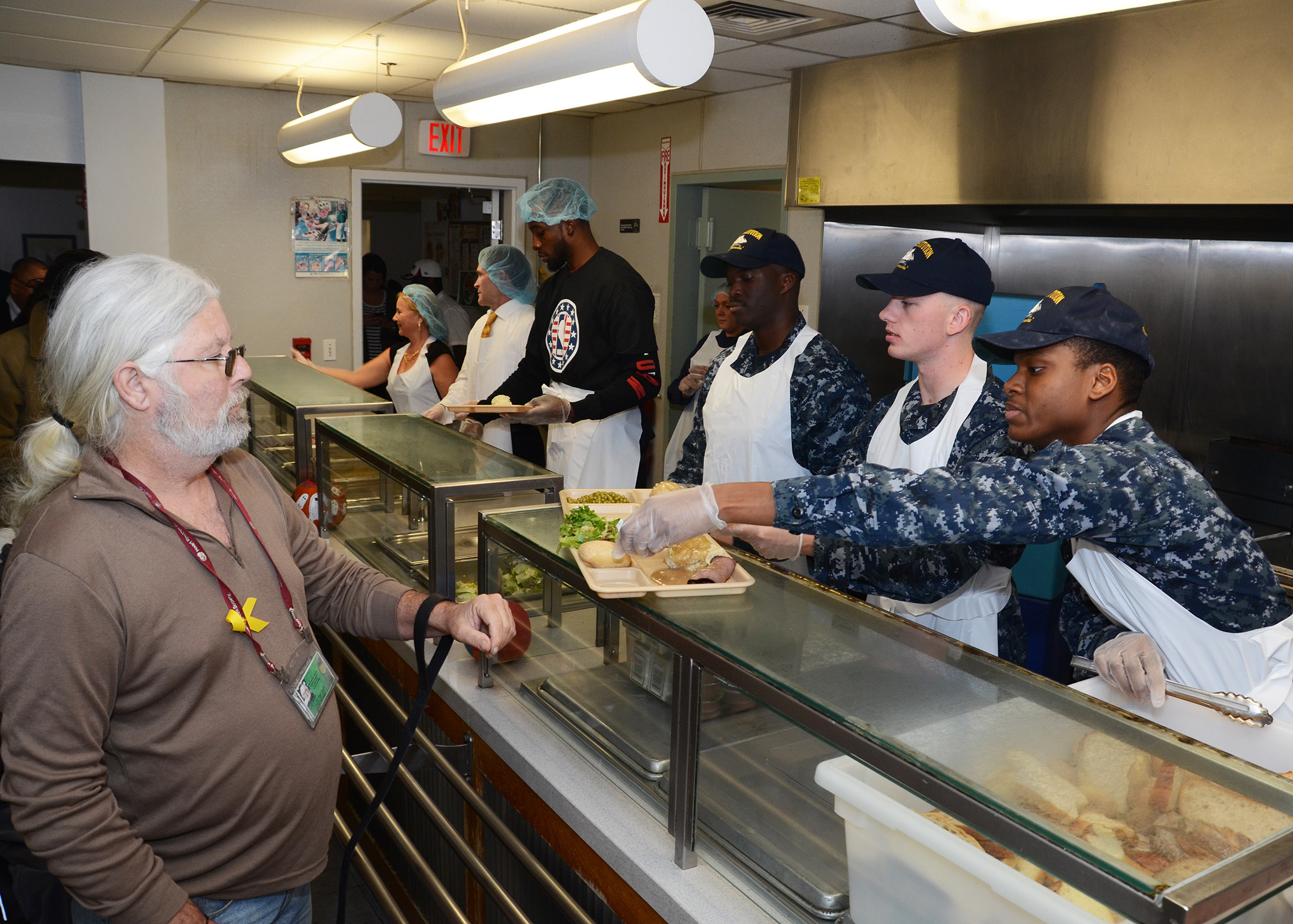 BOSTON (Nov. 10, 2014) Sailors assigned to USS Constitution, alongside Boston Celtics forward Jeff Green, help serve dinner to veterans during a collaborative pre-Veteran's Day volunteer event with the NBA at the New England Center for Homeless Veterans. Current and retired Celtics basketball players joined civilian and military volunteers from the U.S. Navy and Coast Guard to help paint rooms, organize donated clothing and serve hot meals for homeless veterans. U.S. Navy photo by Mass Communication Specialist 2nd Class Peter Melkus.