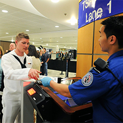 Sailor presents boarding pass at gate.