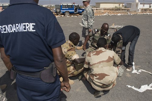 Captain Abdi Daher, Commander of Squadron 2 Gendarmerie Mobile (left) over watches his crew performing medical care during an mass casualty scenario during the First Aid Best Practice Exchange between, the Djibouti Gendarmerie, 404th and 407th Civil Affairs Battalions and the 1-77 Armored Regiment health care specialists in Cheik Moussa, Djibouti, Apr. 4, 2015. (U.S. Air Force Photos by Staff Sgt. Carlin Leslie)