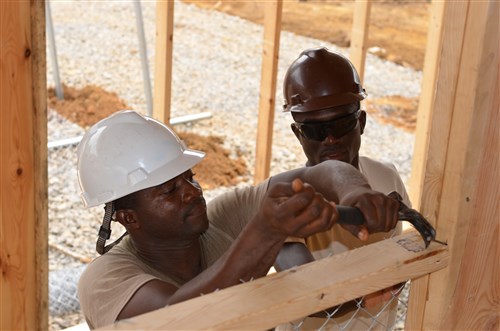 From left, Spc. Deffor Benjamin, a Gettysburg, Md., native, of 615th Engineer Company (Horizontal), 52nd Engineer Battalion, out of Fort Carson, Colo., and armed forces of Liberia Pfc. Matthew Cooper and nail the wood down under a pavilion of an Ebola treatment unit in Gbediah, Liberia, Dec. 19, 2014, in support of Operation United Assistance. Both forces worked together to build the ETU. Operation United Assistance is a Department of Defense operation in Liberia to provide logistics, training and engineering support to U.S. Agency for International Development-led efforts to contain the Ebola virus outbreak in western Africa. (U.S. Army photo by Sgt. Ange Desinor, 13th Public Affairs Detachment/RELEASED)