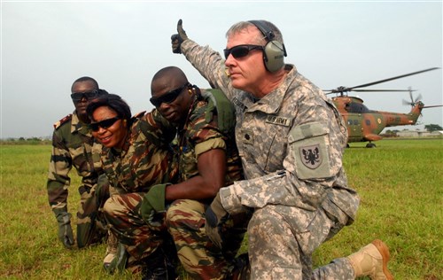 Lieutenant Colonel James Fitzgerald, the battalion commander of Headquarters Company 158th Aviation Regiment, gives the thumbs up to Cameroon pilots flying a Puma Eurocopter helicopter during a casualty evacuation exercise at the Douala Air Force Base Feb. 24. Fitzgerald, the Cameroonian pilots, and the Gabonese Republic and Republic of Congo soldiers next to him were participating in exercise Central Accord 2013, a joint exercise in which U.S., Cameroon and neighboring Central African militaries partner to promote regional cooperation while increasing aerial resupply and medical readiness capacity. (Photo by Staff Sgt. Whitney Hughes)