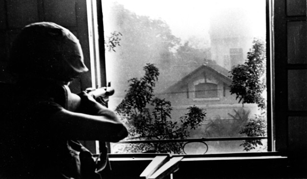 A Leatherneck from 2nd Bn., Fifth Marines, fires his M-79 grenade launcher from a window in Hue University at a North Vietnamese sniper in a nearby building during the Battle of Hue. Marine Corps photo by Sgt. W. F. Dickman