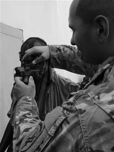 U.S. Army Spc. Christian Kelly, Charlie Company, 411th Civil Affairs Battalion team member, adjusts a Djiboutian soldier’s night vision goggles head mount in Djibouti City, Oct. 10, 2016. Soldiers worked in small teams to navigate obstacles in a dark room to find a designated object and bring it back outside the building during the NVG exercise. (U.S. Air Force photo by Staff Sgt. Benjamin Raughton)