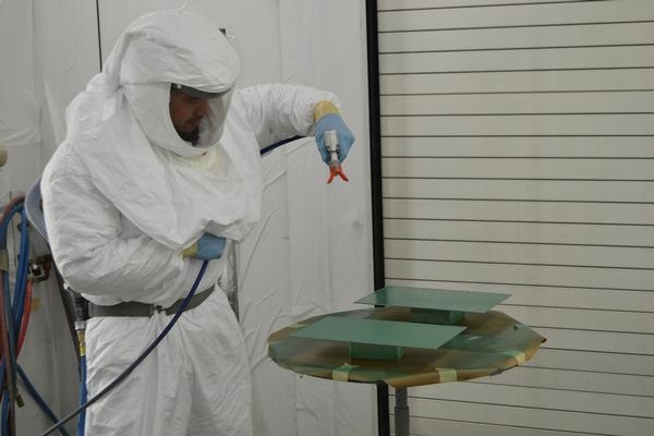 Stephen Chandler, a painter at Fleet Readiness Center Southeast, applies masking to the aircraft skin of an F/A-18 Hornet at the engine finish shop Nov. 13. The masking protects a desired area from the effects of chemical milling. U.S. Navy photo 