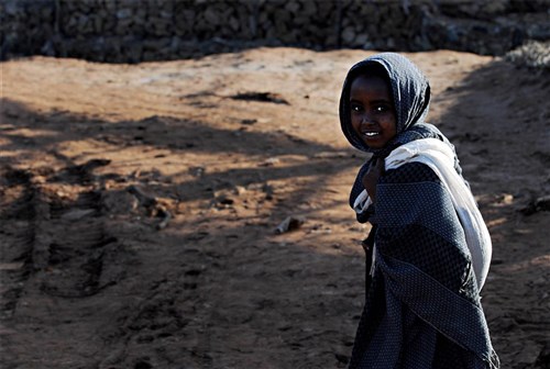 NEGELE BORENA, Ethiopia (Dec. 5, 2011) - A young girl pauses and smiles as she walks toward the original river crossing in Negele Borena, Ethiopia, December 5. U.S. Navy Sailors from Naval Mobile Construction Battalion 5 recently completed a bridge for pedestrians and livestock, which will prevent people from fording through the river to cross it. (U.S. Air Force photo by Senior Airman Jarad A. Denton)