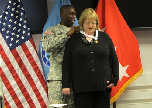 STUTTGART - General "Kip" Ward, commander US Africa Command, presents Mrs. Elizabeth "Liz" Glueck the Commanders Award for Public Service medal and certificate recognizing her contributions to the Stuttgart Military Community, especially the annual Pfenning Bazaar which raised over 90,000 Euro for numerous German and US military community charities.  Mrs. Glueck will accompany her husband, Lt. Gen. select Kenneth Glueck, as they depart AFRICOM this week for Okinawa Japan where Lt. Gen. select Glueck will assume command of the Third Marine Expeditionary Force.(AFRICOM photo by Lt. Col. Steven Lamb)