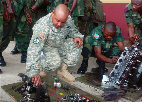 Staff Sgt. Roberto Ortiz, a wheeled vehicle mechanic from AFRICOM’s Regionally Aligned Force, 3rd Brigade, 1st Armored Division from Fort Bliss, Texas, provides assistance to a DRC student rebuilding a light truck engine during hands on training at the DRC Logistics School. (U.S. Army Africa photo)