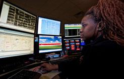 911 call taker looking at 6 screens and using a computer mouse