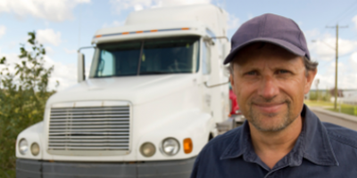 Image of a driver smiling in front of a truck 