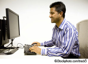 Photo of a man on the phone at a computer