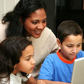 Mother helps children learn to prepare on computer.