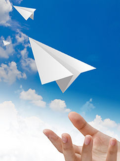 A hand tosses paper airplanes into the sky. (jannoon028/123RF photo)