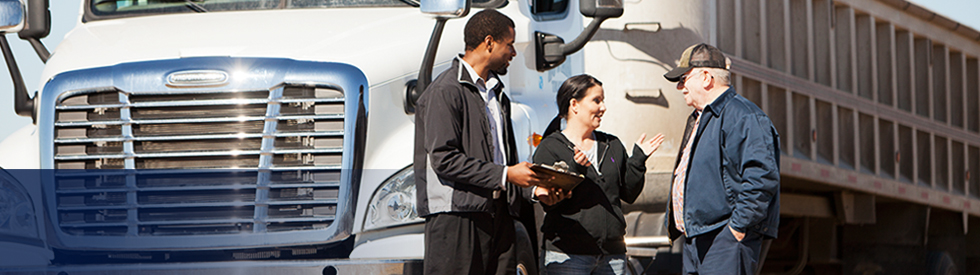 This is an image of a three people conversing beside a truck.