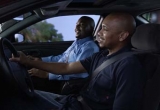 Two men in a vehicle wearing seat belts
