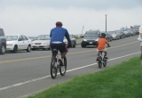 Photo of adult and child riding bicycles in a narrow bike lane