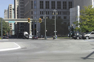 This Detroit intersection illustrates four features that benefit older drivers: far-side traffi c signals centered over each through lane, backplates with reflectorized yellow borders on the traffic signals, painted curb on the median island, and the overhead internally lit street name sign with 30-centimeter (12-inch) letter height. Photo: MDOT.