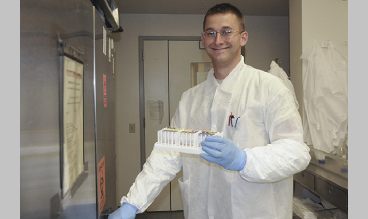 U.S. Army Spc. Chris Springer flashes a smile as he puts some of his work into one of the facility’s many refrigerators. (DoD photo by Katie Lange)