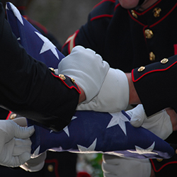 Service members folding the American flag