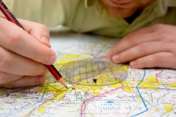 A person plotting points on a map.