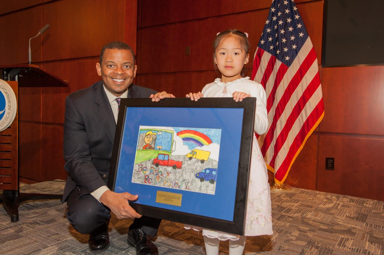 DOT Secretary Anthony Foxx with first-grader Annie Yu from Edison, N.J., who won top honors in the grades K-2 category for the 2014 “Be Ready. Be Buckled.” student art contest.