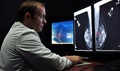 Navy Lt. Cmdr. Erik Ramey, reviews a patient’s x-ray as part of a routine screening mammogram. A mammogram can often detect breast cancer long before it can be felt and usually years before physical symptoms appear. If detected early, breast cancer treatment can be less invasive and more successful.  (DoD photo illustration)