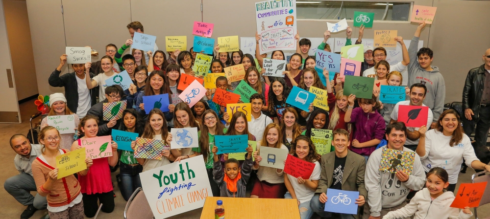 Students gather with signs for a group photo at the 2014 YES Conference