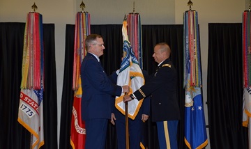 The passing of the Medical Education and Training Campus flag from Air Force Brig. Gen. James Dienst, director of the Defense Health Agency's education & training directorate, to Army Col. Jack Davis signals that the responsibility and authority of leading METC has been bestowed upon the new commandant.  (Photo by Lisa Braun)