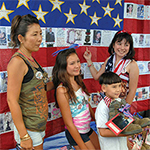 Family in front of flag on wall