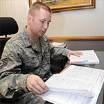 Service member at desk with books