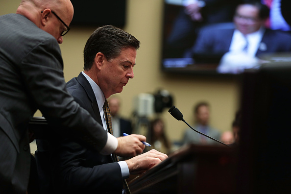 FBI Director James Comey listens to an aide during a hearing before House Oversight and Government Reform on Capitol Hill in Washington, D.C.   