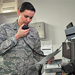 Service member speaking into two-way radio microphone