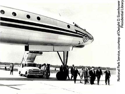 At Andrews Air Force Base, President Eisenhower (second from right, with hat, in front row) and Premier Khrushchev (to the President’s right) walk from the Premier’s TU-114 airplane. After taking office in 1953, the Premier had been embarrassed by the Soviet Union’s small official airplane. He ordered aircraft designer Andrei Tupolev to build the biggest airplane possible. According to author Peter Carlson,