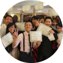 Schoolkids hold up mock diplomas in a college prep program.