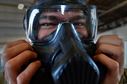Airman 1st Class Kyle Denzine, a 20th Operations Support Squadron aircrew flight equipment specialist, checks the seal of his gas mask at Shaw Air Force Base, S.C., Oct. 23, 2015. Denzine, along with other AFE Airmen, practiced the actions they would take in the event a pilot needs to be decontaminated upon his return to base. (U.S. Air Force photo/Senior Airman Michael Cossaboom)