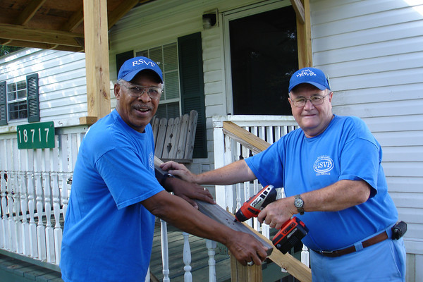 Two RSVP volunteers work on a project to improve accessibility to a home.