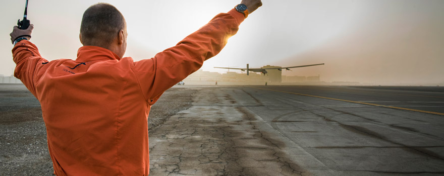 Back view of a man raising his arms happily as a solar flight takes off