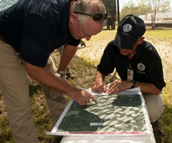 Dos hombres ven un mapa para coordinar evacuaciones.