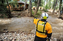 La Agencia Federal para el Manejo de Emergencias (FEMA, por sus siglas en inglés) observa cómo el equipo lleva a cabo la búsqueda de una casa que ahora se encuentra dentro del río en la boca del cañón Left Hand.