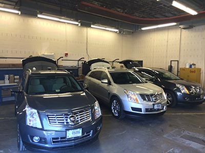Figure 2: This photograph shows three side-by-side Cadillac sport utility vehicles in the Vehicle Preparation Garage at the Turner-Fairbank Highway Research Center.