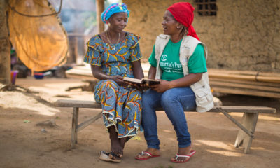 A Samaritan's Purse staff member reads the Bible with Kpanna, a local church leader. Our staff share God's Word before beginning each leadership class.