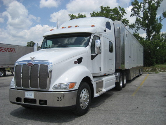 The front angled view of a large white semi truck and trailer.